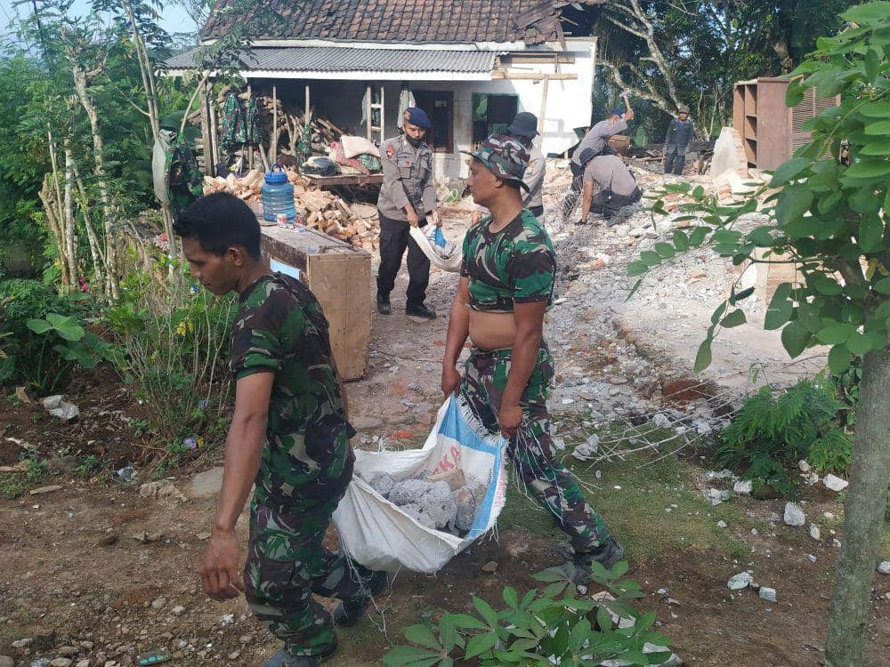 Sejumlah anggota TNI dan Polri bahu-membahu membantu warga untuk membersihkan puing bangunan yang runtuh pasca gempa di Desa Wirotaman, Ampelgading. IDN Times/Alfi Ramadana