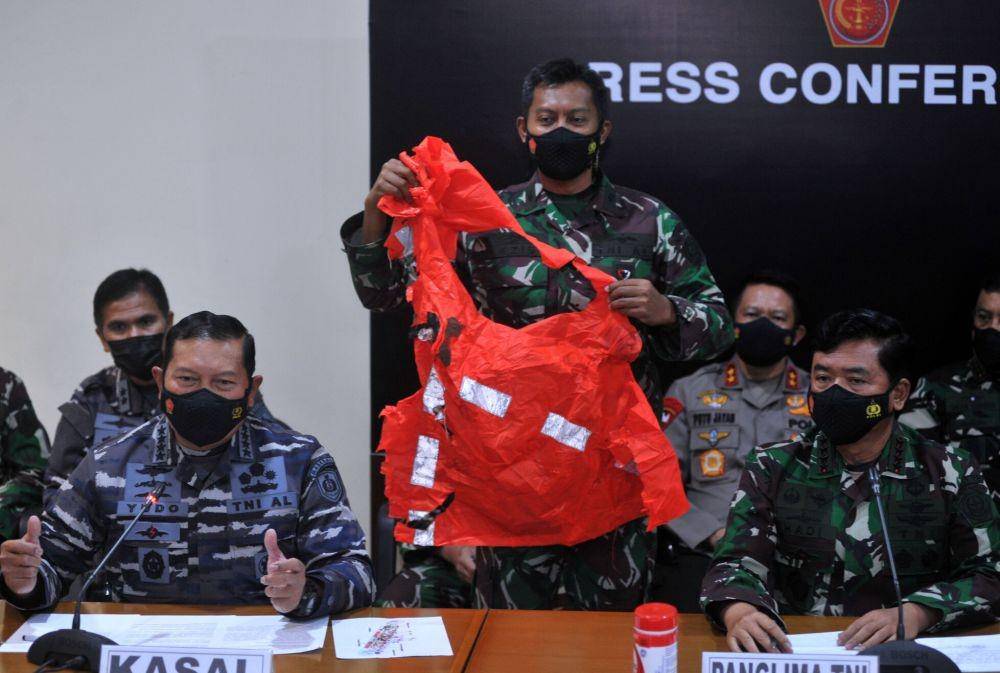 Panglima TNI Marsekal TNI Hadi Tjahjanto (kanan) dan Kepala Staf Angkatan Laut Laksamana TNI Yudo Margono (kiri) menunjukkan baju keselamatan awak kapal KRI Nanggala 402. (ANTARA FOTO/Fikri Yusuf)