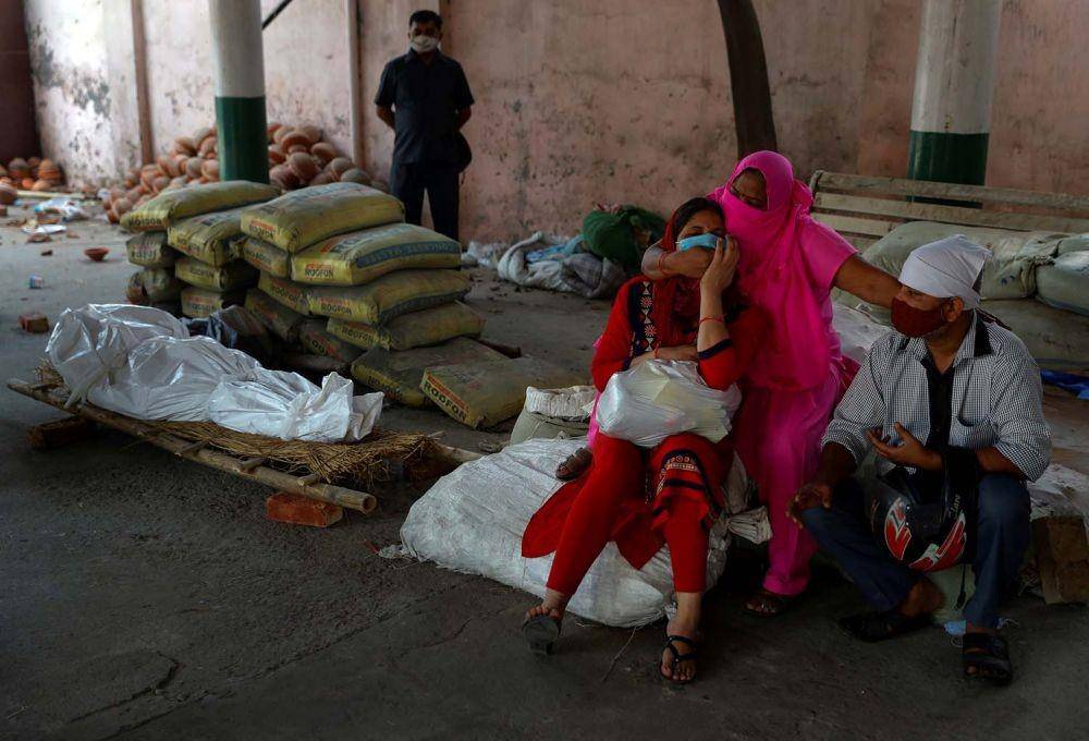 Kerabat berduka ketika mereka duduk di sebelah tubuh orang yang meninggal karena penyakit virus corona (COVID-19) selama kremasi massal di krematorium di New Delhi, India, Senin (26/4/2021). ANTARA FOTO/REUTERS/Adnan Abidi