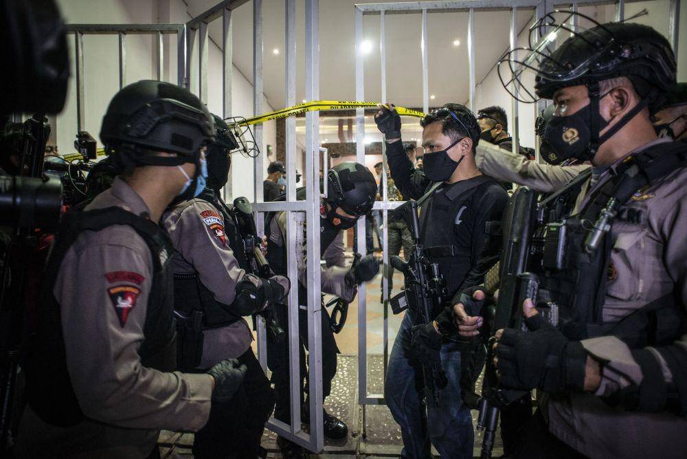 Personel kepolisian bersenjata dan prajurit TNI berjaga saat tim Densus 88 Antiteror melakukan penggeledahan di bekas markas Front Pembela Islam (FPI), Petamburan, Jakarta, Selasa (27/4/2021). (ANTARA FOTO/Aprillio Akbar)