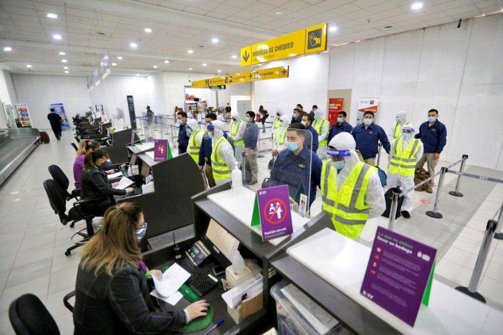 Para imigran Venezuela yang mengenakan baju putih didampingi oleh petugas imigrasi Chile untuk dipulangkan menggunakan pesawat komersial di Bandara Iquique. (twitter.com/elvinotintocl)