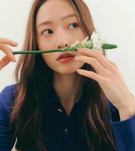 Krystal berfoto dengan setangkai bunga. (instagram.com/vousmevoyez)