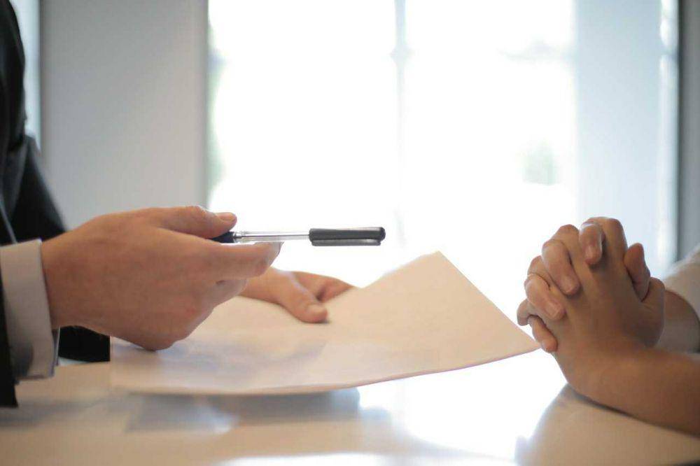 Perekrut memberikan kertas dan pulpen ke kandidat (pexels.com/Andrea Piacquadio)