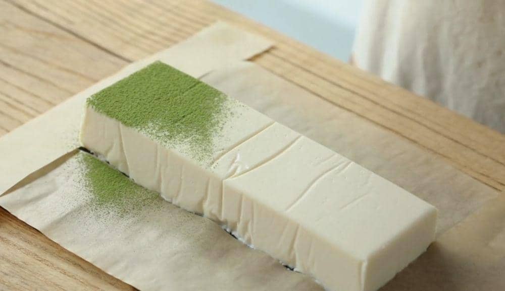 Taburkan bubuk matcha ke atas cheesecake. (dok. TikTok/CookingSpring)