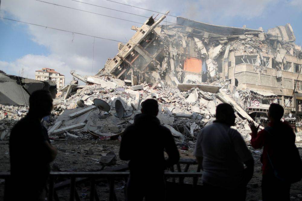 Warga Palestina melihat reruntuhan bangunan yang hancur akibat serangan udara Israel, di tengah gejolak kekerasan Israel-Palestina, di Kota Gaza, Kamis (13/5/2021). ANTARA FOTO/REUTERS/Suhaib Salem.