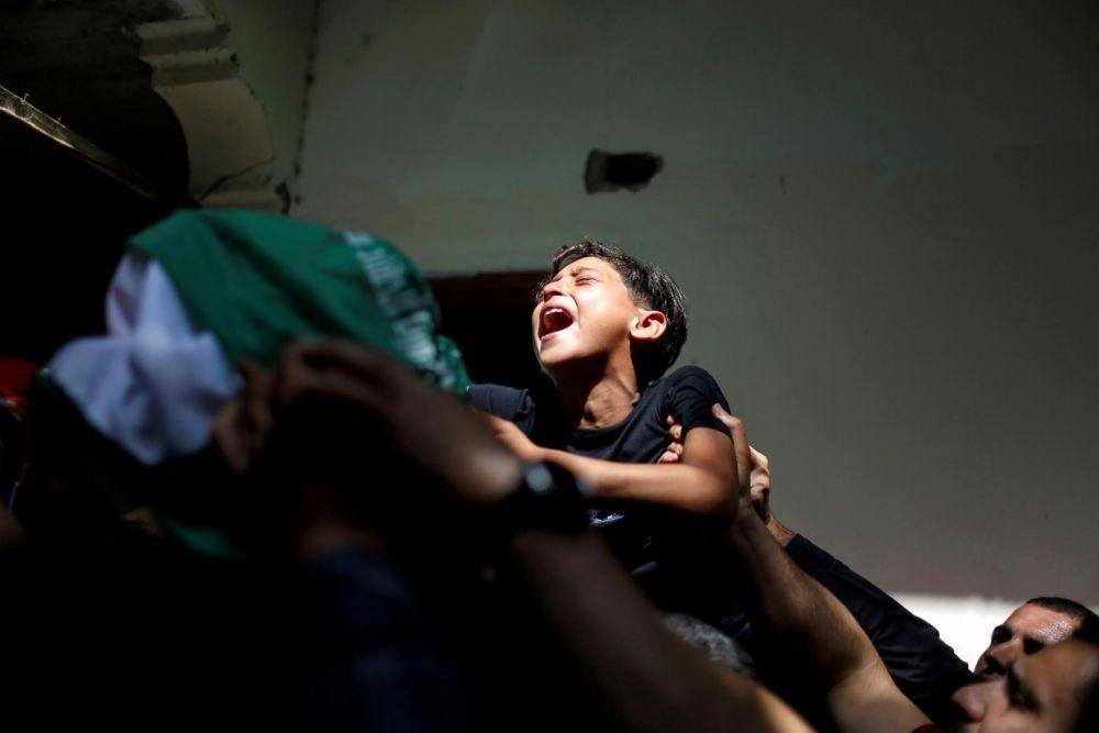 Saudara laki-laki Palestina Ahmed Al-Shenbari, yang terbunuh di tengah meningkat nya kekerasan Israel-Palestina, bereaksi ketika pelayat membawa tubuhnya selama pemakamannya di Jalur Gaza utara Mei, Selasa (11/5/2021). ANTARA FOTO/REUTERS/Mohammed Salem.