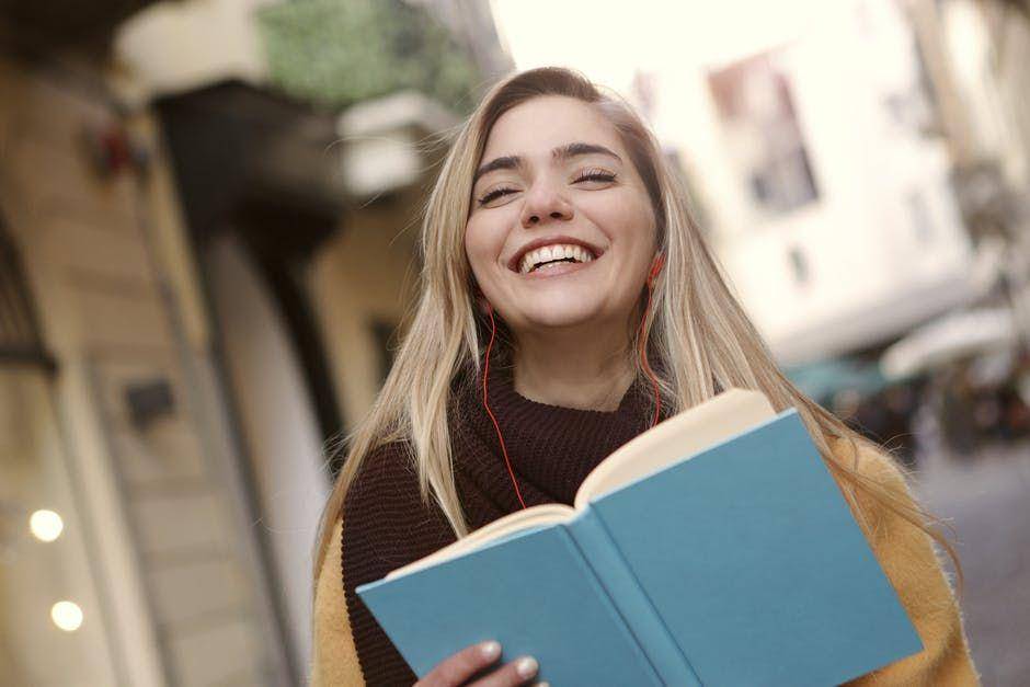 ilustrasi wanita tersenyum memegang buku (Pexels.com/Andrea Piacquadio)