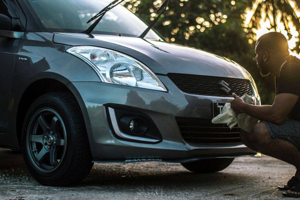 Pria membersihkan mobil Suzuki Swift (pexels/Sleepi Alleyne)