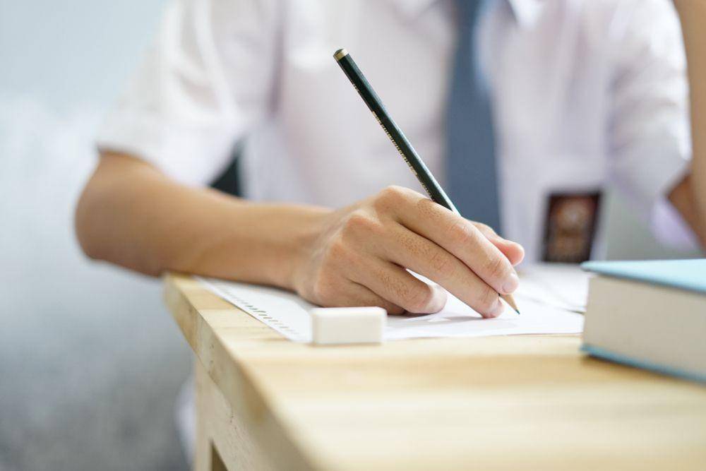 Seorang pelajar tengah menulis (ShutterStock/Quon_ID)
