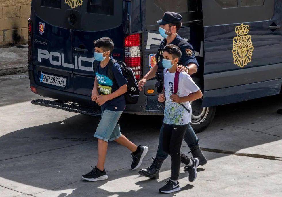 Dua imigran anak asal Maroko dan seorang anggota polisi Spanyol di Ceuta. (twitter.com/Alonso_Medinas)