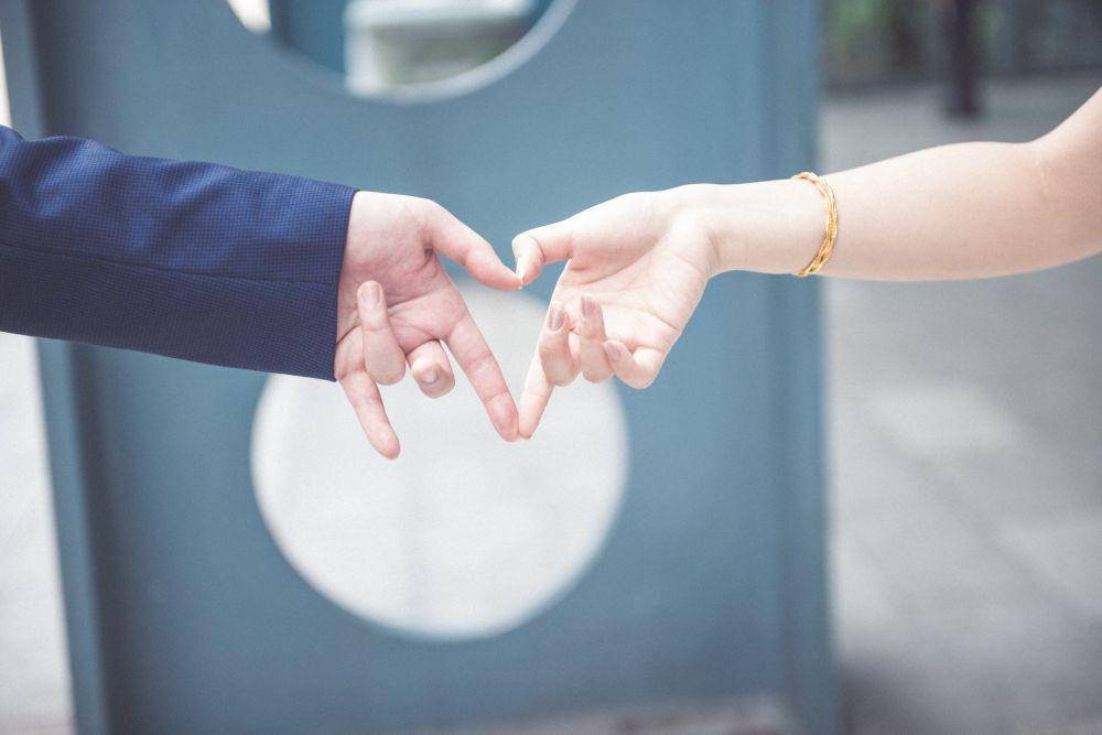 Ilustrasi pasangan melakukan love sign. (unsplash.com/han hsing)