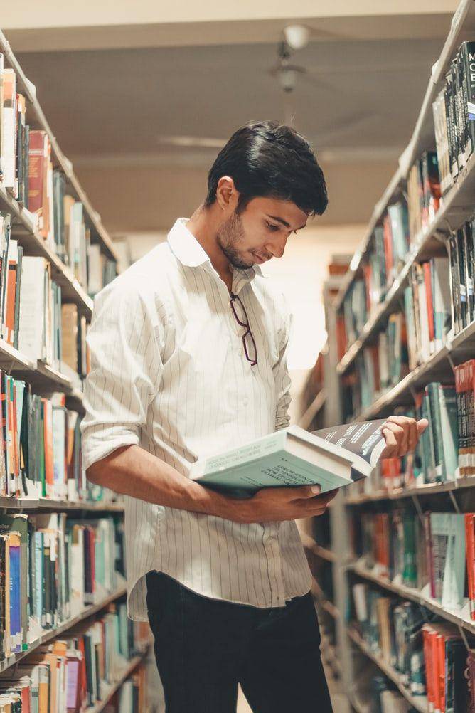 Ilustrasi pria yang hobi membaca buku (Unsplash.com/Dollar Gill)