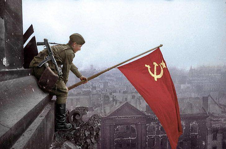 potret seorang tentara mengibarkan bendera Uni Soviet. (wallpaperbetter.com)