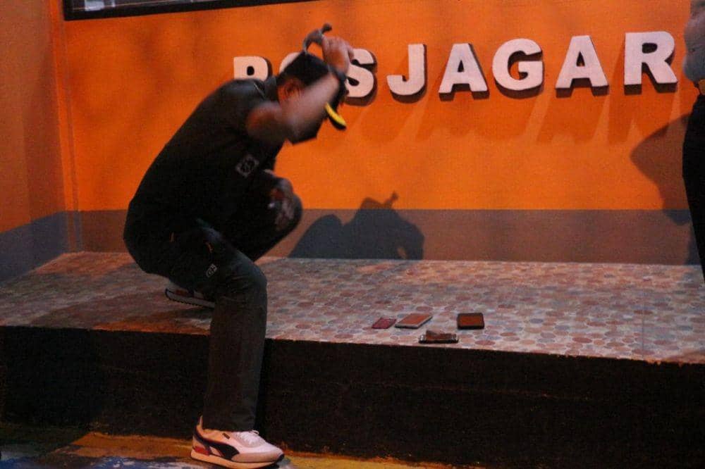 Kepala Rutan Kelas 1 Depok, Anton menghancurkan handphone yang disimpan WBP di dalam kamar. (Humas Rutan Depok)