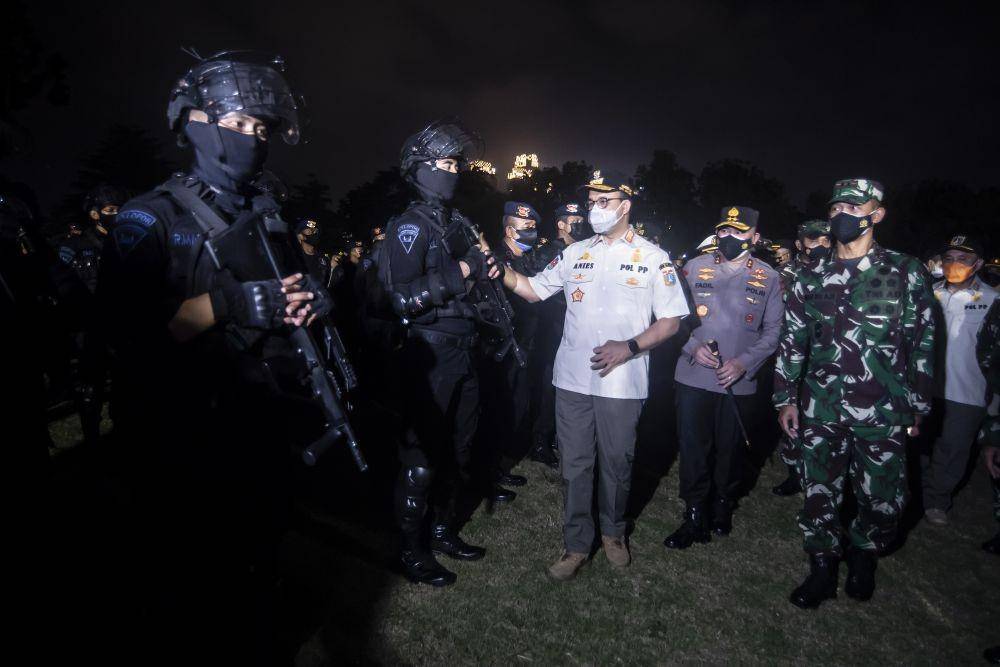 Gubernur DKI Jakarta Anies Baswedan (ketiga kanan) bersama Pangdam Jaya Mayjen TNI Mulyo Aji (kanan) dan Kapolda Metro Jaya Irjen Fadil Imran (kedua kanan) memeriksa kesiapan pasukan usai mengikuti apel bersama Penegakan Pendisiplinan PPKM Berskala Micro TA 2021 di Jakarta, Minggu (13/6/2021) (ANTARA FOTO/Muhammad Adimaja)