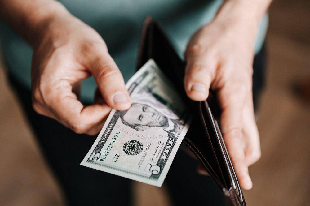 Seseorang yang memegang selembar uang (pexels.com/ Karolina Grabowska)