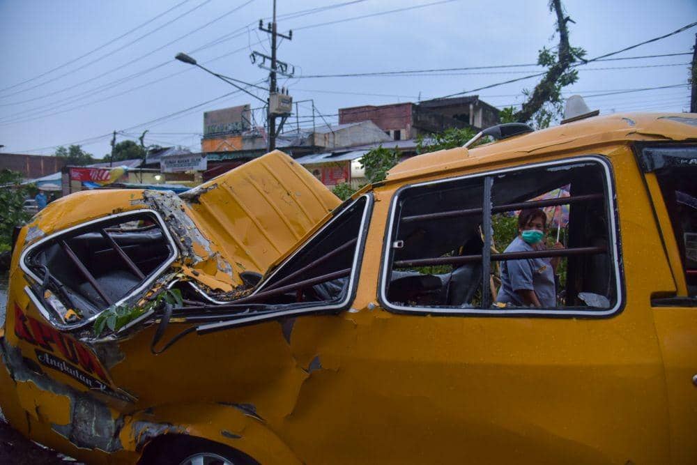 Warga mengamati mobil yang tertimpa pohon tumbang di depan Rumah Sakit Adam Malik, Medan Tuntungan, Medan, Sumatera Utara, Senin (28/6/2021). (ANTARA FOTO/Fransisco Carolio)