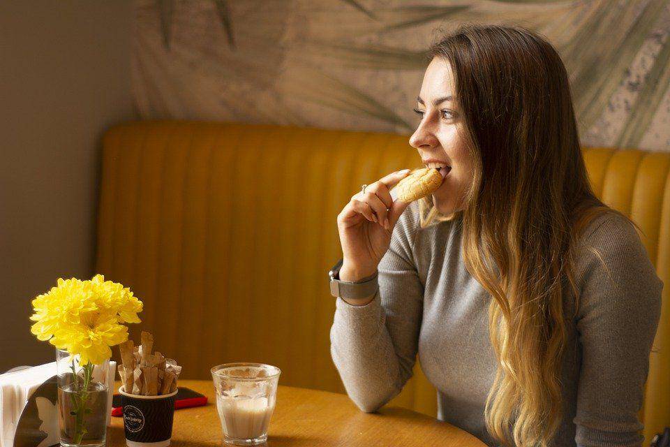 Girl cafe eating cafeteria snack (pixabay/Nimka93)