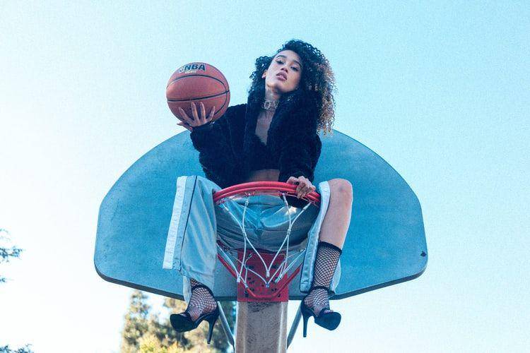 ilustrasi perempuan duduk di atas ring basket (unsplash.com/matthew reyes)