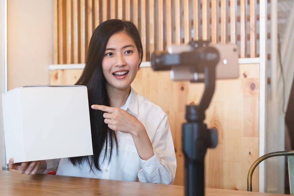 Seorang wanita sedang menjelaskan sesuatu di kontennya (Shutterstock.com/Pormezz)