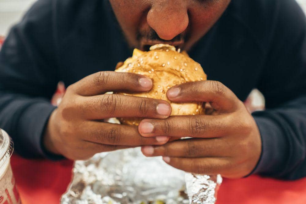 ilustrasi makan burger (unsplash.com/Marcel Heil)
