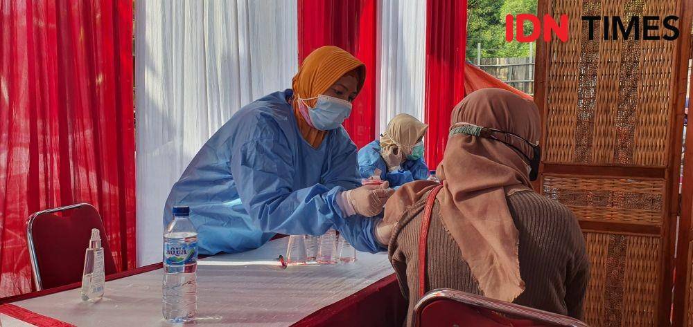 Petugas kesehatan memberikan suntikan vaksin pada vaksinasi Presisi Polsek Sawangan di kawasan kumuh. (IDNTimes/Dicky)