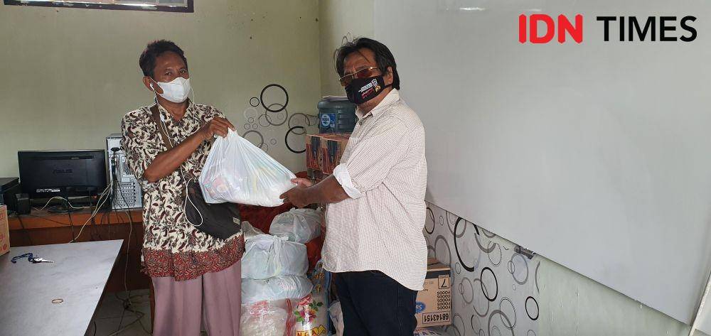 Ketua Satgas COVID-19 Kelurahan Serua, Toto saat memberikan bantuan sembako kepada warga Isoman melalui pengurus lingkungan. (IDNTimes/Dicky)