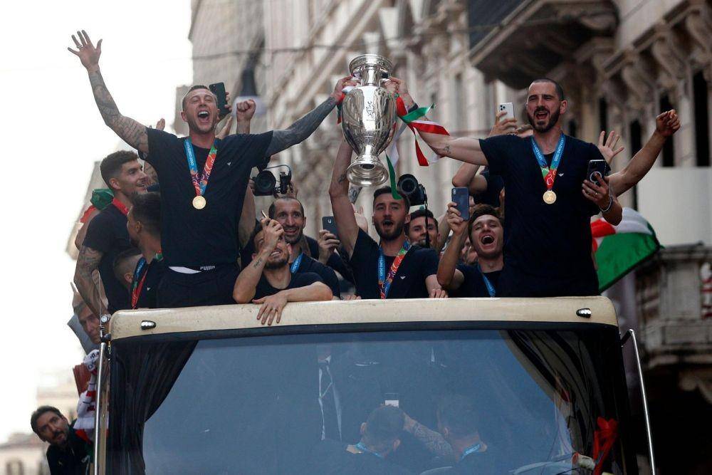 Leonardo Bonucci dari Italia dan Federico Bernardeschii dari Italia mengangkat trofi di bus selama tur Euro 2020, Roma, Italia, Senin (12/7/2021). ANTARA FOTO/REUTERS/Guglielmo Mangiapane