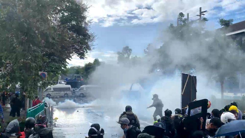 Demonstran Thailand bentrok dengan petugas polisi pada hari Minggu (18/7). Polisi menggunakan gas air mata, meriam air dan peluru karet untuk membubarkan kerumunan protes. (Twitter.com/May Wong)