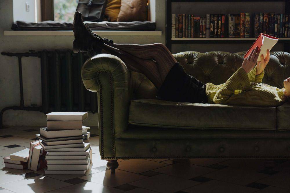 Seorang perempuan membaca buku di sofa (pexels.com/cottonbro)