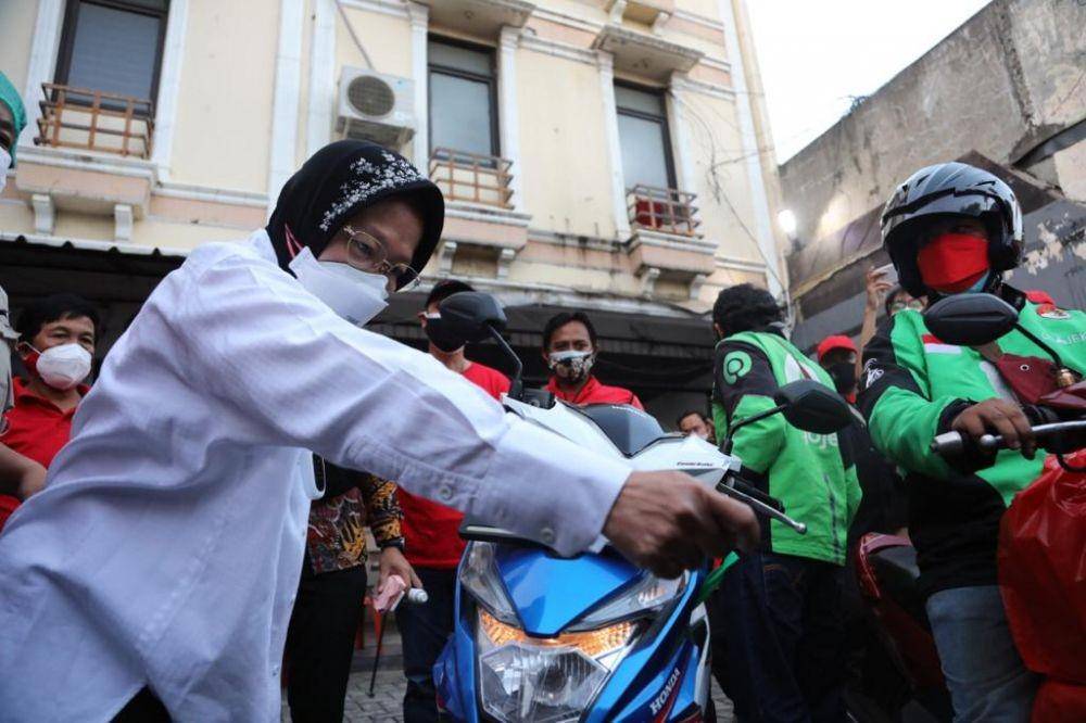 Menteri Sosial Tri Rismaharini membagikan makanan di dapur umum pada masyarakat terdampak COVID-19. (dok. Kemensos)