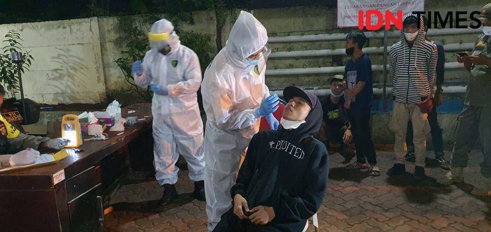 Petugas kesehatan melakukan swab antigen di Polsek Sawangan. (IDNTimes/Dicky)