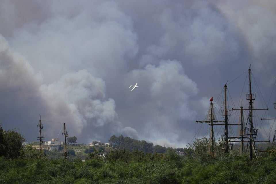 Pesawat pembawa bom air terlihat terbang di atas kepulan asap kebakaran hutan yang melanda Manavgat, di provinsi Antalya, Turki selatan. (Twitter.com/severe-weather.EU)