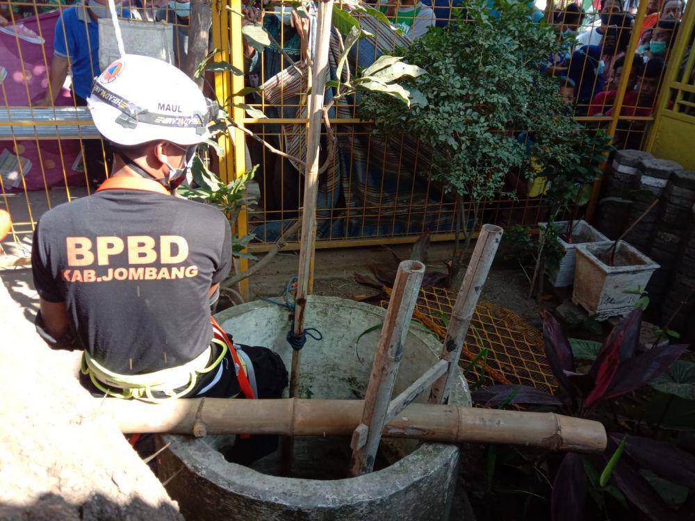 Petugas BPBD Jombang mengevakuasi korban dari dalam sumur. IDN Times/Zainul Arifin