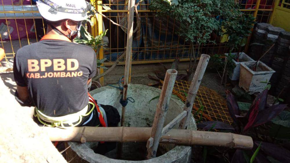 Petugas BPBD Jombang mengevakuasi korban dari dalam sumur. IDN Times/Zainul Arifin