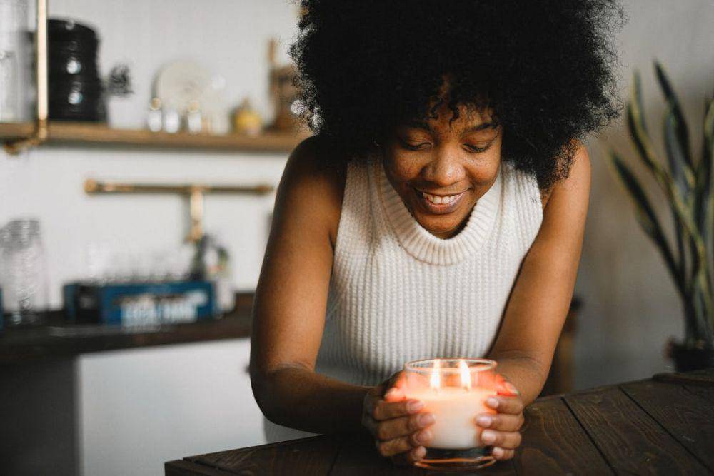 Ilustrasi seorang wanita menyalakan scented candle (Pexels.com/Anna Shvets)
