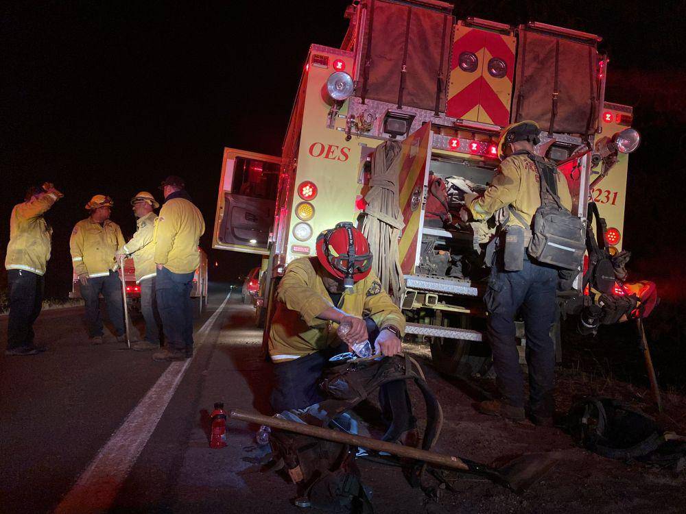 Para petugas pemadam yang sedang mengatur perlengkapan untuk memadamkan api Dixie Fire. (Twitter.com/KRCR PHOTOG)