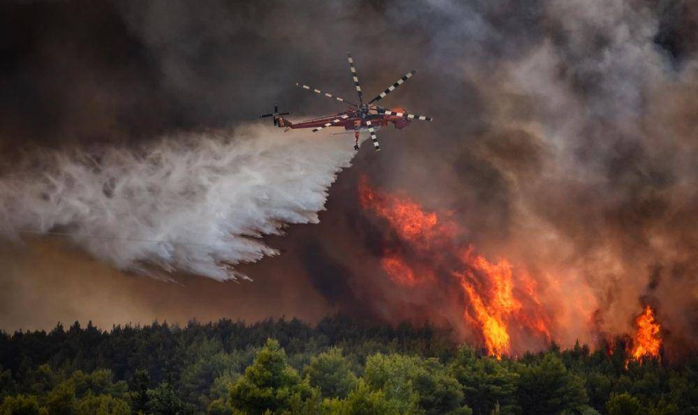 Helikopter menjatuhkan bom air untuk memadamkan api yang membakar hutan di Yunani. (Twitter.com/Choose Love)