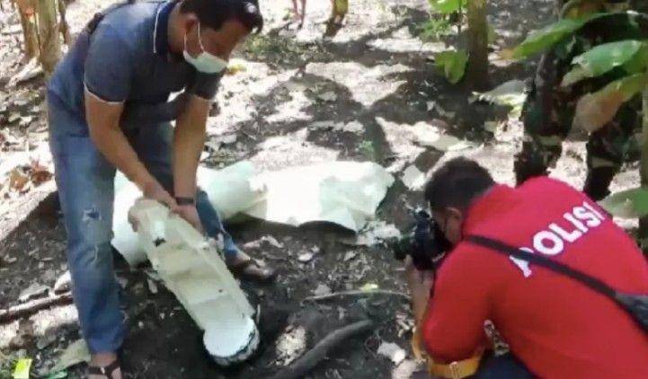 Petugas memeriksa temuan benda yang diduga serpihan pesawat di Desa Dawu, Kecamatan Paron, Kabupaten Ngawi, Jawa Timur, Selasa 10 Agustus 2021. (ANTARA FOTO/Louis Rika)