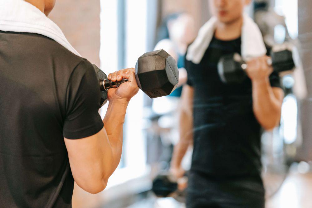 Ilustrasi seorang pria sedang melatih otot lengan menggunakan dumbbell (Pexels.com/Andres Ayrton)