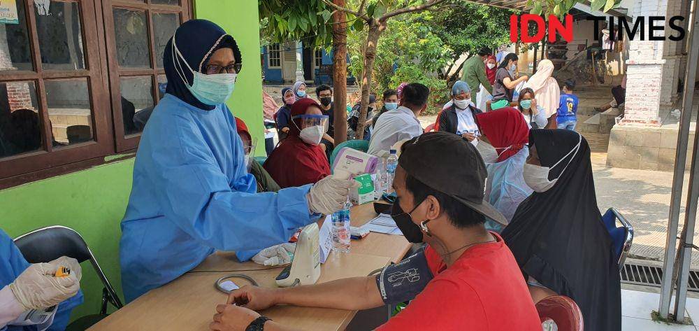 Petugas kesehatan melakukan screening kepada warga yang mengikuti vaksinasi Polsek Sawangan di Kelurahan Kedaung, Kecamatan Sawangan, Kota Depok. (IDNTimes/Dicky)