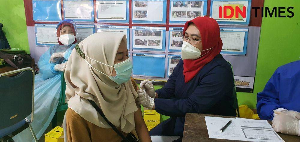 Salah seorang warga takut melihat suntikan vaksin pada vaksinasi Polsek Sawangan di Kelurahan Kedaung, Kecamatan Sawangan, Kota Depok. (IDNTimes/Dicky)