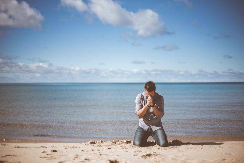 seorang pemuda yang sedang berdo di pinggir pantai (unsplash.com/@benwhitephotography)