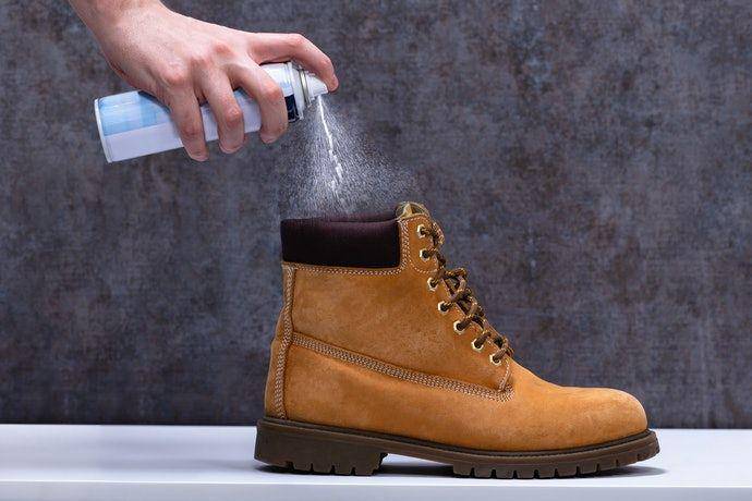 Menyemprotkan pewangi sepatu untuk menghilangkan bau dan kuman akibat pemakaian dengan kaos kaki (my-best.id)