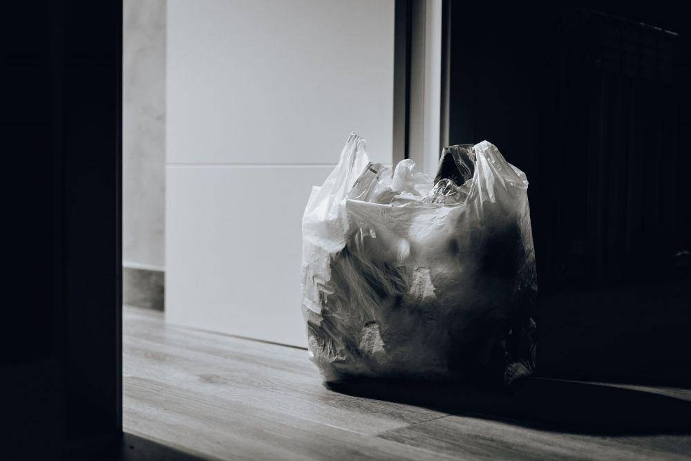 ilustrasi meletakkan sampah di dalam kantong plastik di dekat pintu (Pexels.com/Juan Pablo Serrano)