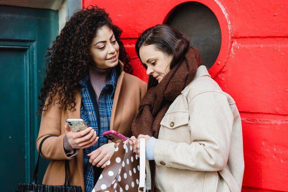 ilustrasi dua perempuan sedang berbagi foto (pexels.com/Tim Douglas)