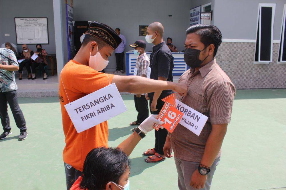 Tersangka memperagakan adegan dalam rekontruksi penganiayaan. IDN Times/ istimewa