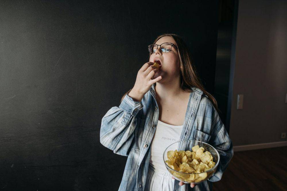 ilustrasi seseorang makan makanan tidak sehat (pexels.com/Pavel Danilyuk)