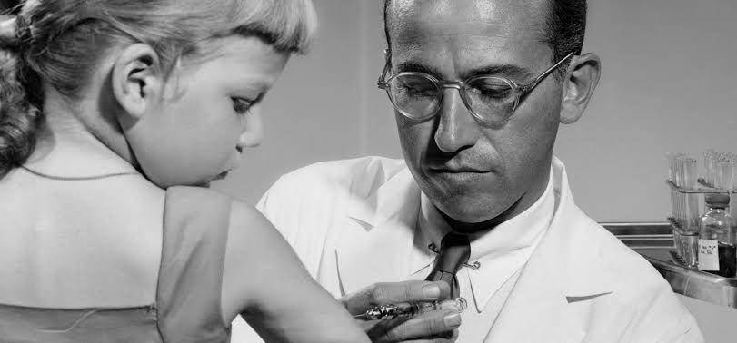 Jonas Salk menyuntikkan vaksin pada seorang anak (thenewatlantis.com)
