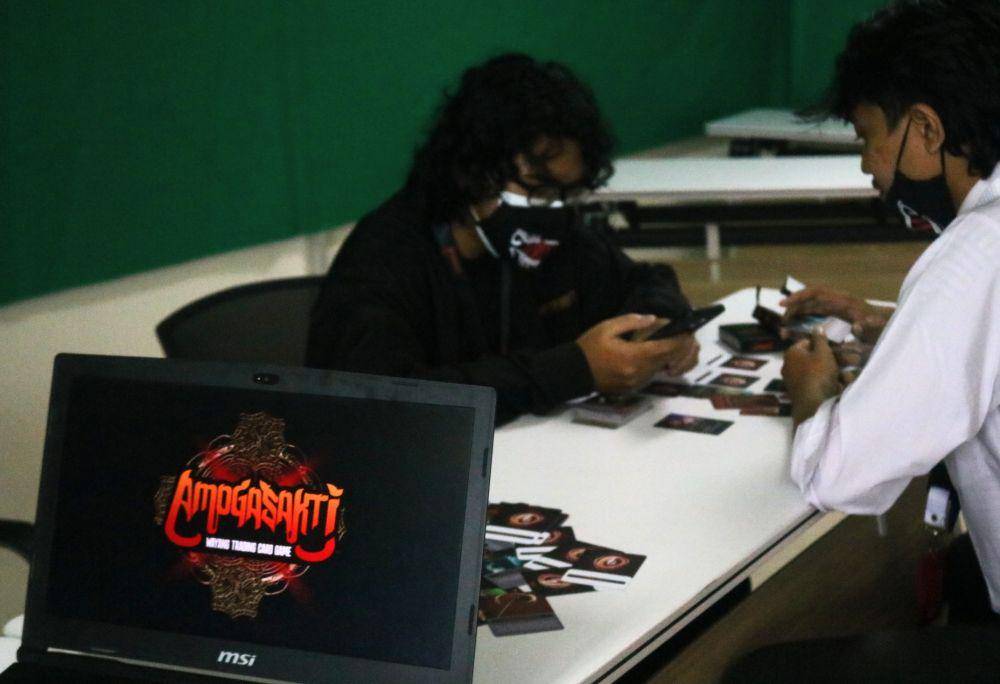 Dua pemuda sedang bermain wayang trading card game. IDN Times/Alfi Ramadana